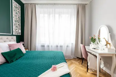 a bedroom with a green bed and a desk and a mirror at Luxe Living Krakow in Kraków