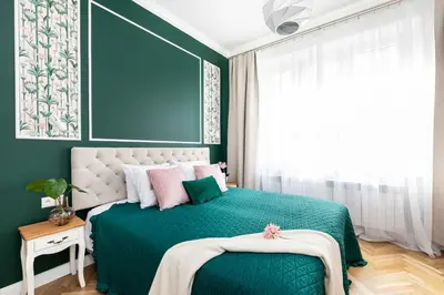 a bedroom with a green bed and a large window at Luxe Living Krakow in Kraków