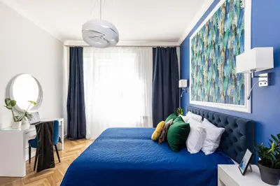 a blue bedroom with a blue bed with pillows at Luxe Living Krakow in Kraków