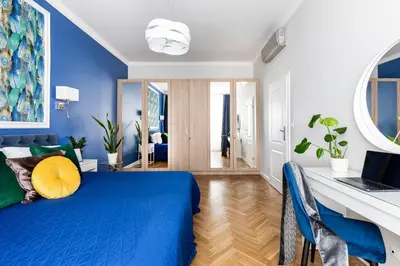 a blue bedroom with a blue bed and a desk at Luxe Living Krakow in Kraków