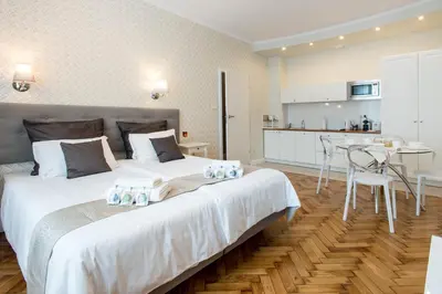 a bedroom with a large bed and a kitchen at Luxe Living Krakow in Kraków