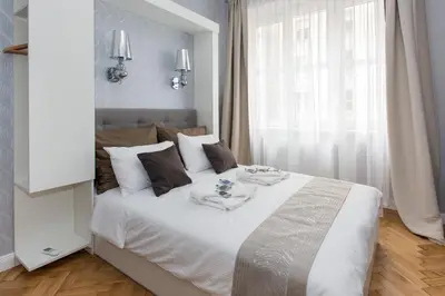 a white bed in a room with a window at Luxe Living Krakow in Kraków