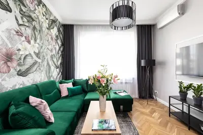 a living room with a green couch and a table at Luxe Living Krakow in Kraków