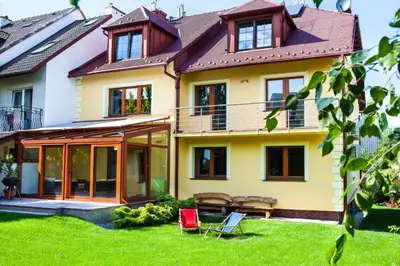 a house with a green yard with red chairs at Apartamenty SaltApart in Wieliczka