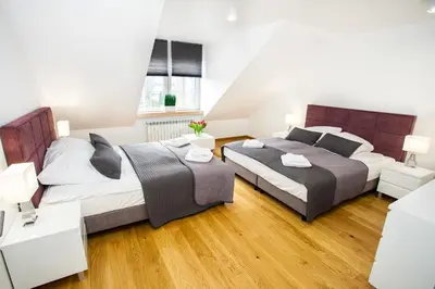 two beds in a bedroom with two lamps at Apartamenty SaltApart in Wieliczka