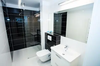 a white bathroom with a toilet and a sink at Apartamenty SaltApart in Wieliczka