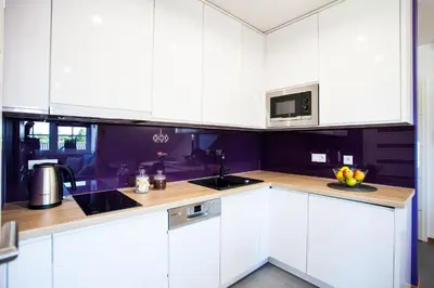 a kitchen with white cabinets and a sink and a microwave at Apartamenty SaltApart in Wieliczka
