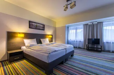 a room with a bedroom with a bed and a mirror at Beskid in Zawoja
