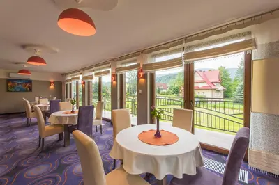 a dining room with green tables and chairs at Beskid in Zawoja