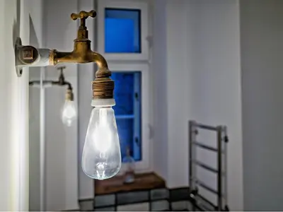 a light bulb hanging from a faucet in a kitchen at Kurkowa Apartments in Kraków