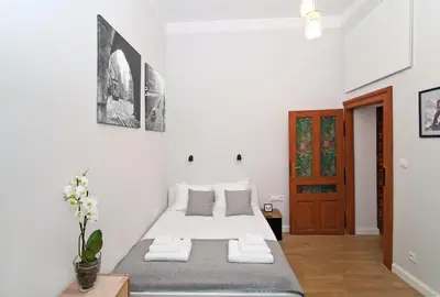 a white bedroom with a bed with two pillows at Kurkowa Apartments in Kraków