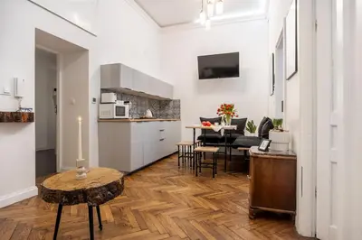 a kitchen and a living room with a table at Kurkowa Apartments in Kraków
