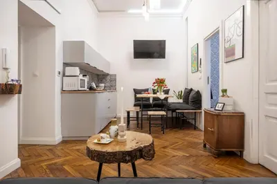 a living room with a table and a kitchen at Kurkowa Apartments in Kraków