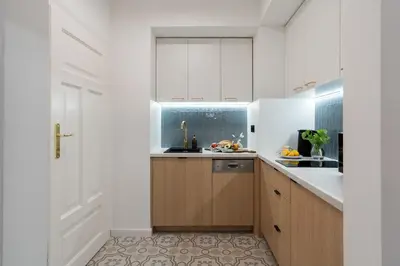 a kitchen with white cabinets and a sink at Sleeping in Krakow Main Market in Kraków