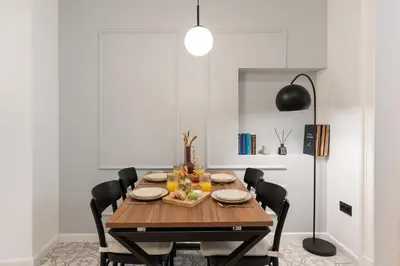 a dining room with a wooden table and black chairs at Sleeping in Krakow Main Market in Kraków