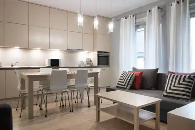 a kitchen and living room with a table and a couch at Yourplace Biskupia Old Town Apartments in Kraków