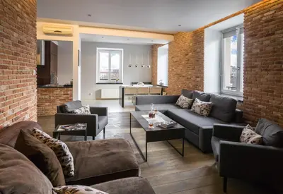 a living room with couches and a brick wall at Yourplace Biskupia Old Town Apartments in Kraków