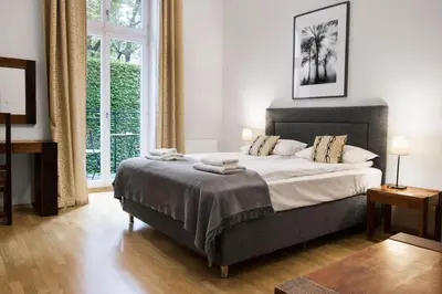 a bedroom with a large bed and a large window at Yourplace Biskupia Old Town Apartments in Kraków