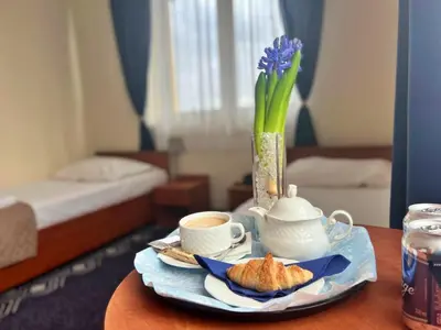 a table with a tea pot and a vase with flowers at Hotel Vistula in Kraków