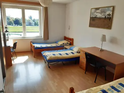 a room with two beds and a desk and a desk sidx sidx sidx at Salwator Apartments in Kraków