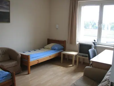 a small room with a bed and a tv at Salwator Apartments in Kraków