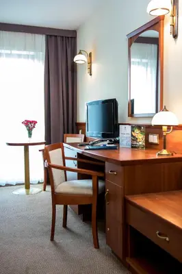 a hotel room with a desk with a computer and a chair at Hotel Great Polonia Conrad Kraków in Kraków