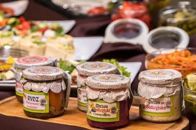 a table topped with jars of jam and vegetables at Hotel Great Polonia Conrad Kraków in Kraków