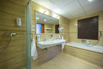 a bathroom with a sink and a tub and a mirror at Hotel Great Polonia Conrad Kraków in Kraków
