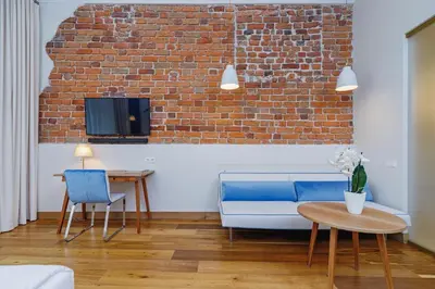 a living room with a blue couch and a brick wall at Apartamenty Bracka 6 in Kraków