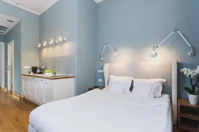 a bedroom with a large white bed with white pillows at Apartamenty Bracka 6 in Kraków