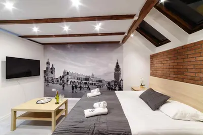 a bedroom with a large bed and a wall mural at Cracow Rent Apartments - spacious apartments for 2-7 people in quiet area - Kolberga Street nr 3 - 10 min to Main Square by foot in Kraków