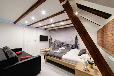 a bedroom with a large bed and a couch at Cracow Rent Apartments - spacious apartments for 2-7 people in quiet area - Kolberga Street nr 3 - 10 min to Main Square by foot in Kraków