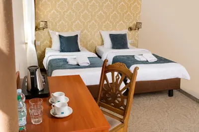 a hotel room with two beds and a table with a table sidx sidx at Aparthotel Globus Self-Check in in Kraków