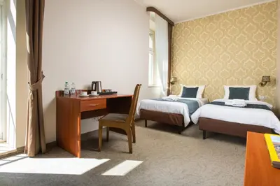 a room with two beds and a desk and a desk at Aparthotel Globus Self-Check in in Kraków