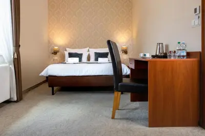 a bedroom with a bed and a desk with a chair at Aparthotel Globus Self-Check in in Kraków