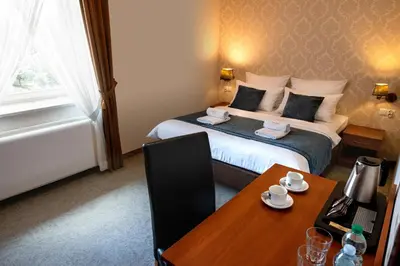 a hotel room with a bed with a desk and a table at Aparthotel Globus Self-Check in in Kraków