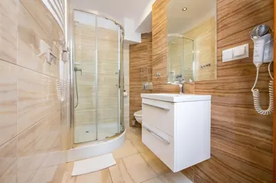a bathroom with a shower and a sink and a phone at Aparthotel Globus Self-Check in in Kraków