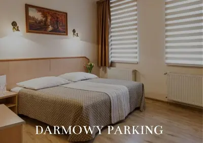 a bedroom with a bed and two windows at Antica Residence in Kraków