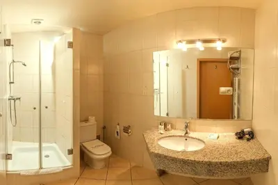 a bathroom with a sink and a toilet and a mirror at Antica Residence in Kraków