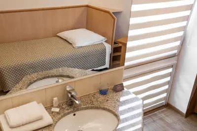 a bathroom with a sink and a bed at Antica Residence in Kraków
