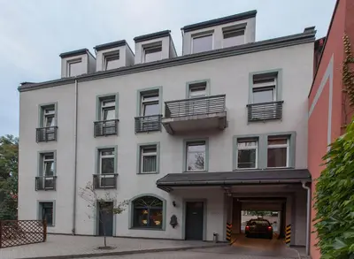 a white building with balconies on top of it at Antica Residence in Kraków