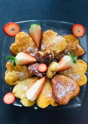 a plate of food with fruit on a table at Antica Residence in Kraków