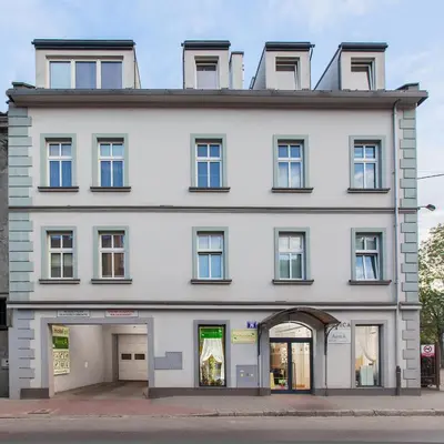 a large white building with a store front at Antica Residence in Kraków
