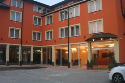 a large orange building with cars parked in a parking lot at Daisy Superior in Kraków