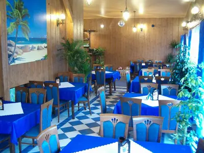 a dining room with blue tables and chairs at Daisy Superior in Kraków