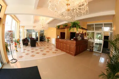 a lobby with a waiting area with a chandelier at Daisy Superior in Kraków