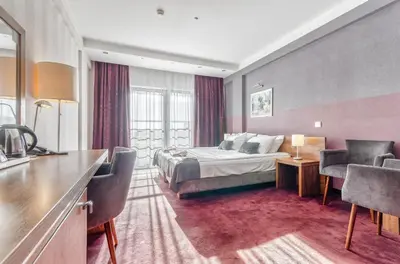 a hotel room with a bed and a table and chairs at Hotel Swing in Kraków