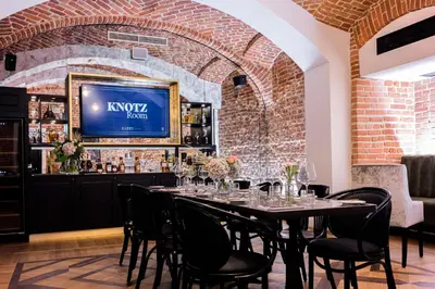 a dining room with a table with chairs and a tv at Hotel Saski Krakow Curio Collection by Hilton in Kraków