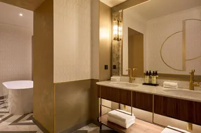 a bathroom with a tub and a glass shower at Hotel Saski Krakow Curio Collection by Hilton in Kraków