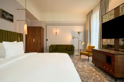 a hotel room with two beds and a table at Hotel Saski Krakow Curio Collection by Hilton in Kraków